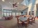 Large recreation room with multiple tables, chairs, ceiling fans, and abundant natural light at 1003 Teal Pointe, Tarpon Springs, FL 34689