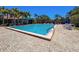 This shot showcases the large community pool, complemented by an array of lounge chairs and umbrellas for relaxation at 1003 Teal Pointe, Tarpon Springs, FL 34689