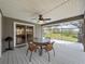 Relaxing covered patio with a table, chairs, a ceiling fan and views of the expansive backyard at 1003 Teal Pointe, Tarpon Springs, FL 34689