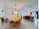 Open concept floor plan features a dining room with tile floors, lighting fixture, and view to the living room at 1003 Teal Pointe, Tarpon Springs, FL 34689