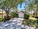 Charming one-car garage with lovely landscaping and mature trees, offering shade and curb appeal at 1003 Teal Pointe, Tarpon Springs, FL 34689