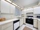 Bright kitchen with white cabinetry, tile floors, and stainless steel dishwasher and appliances at 1003 Teal Pointe, Tarpon Springs, FL 34689