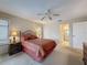 Comfortable main bedroom featuring a queen size bed, ceiling fan, and en-suite bathroom at 1003 Teal Pointe, Tarpon Springs, FL 34689