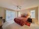 This main bedroom boasts carpet floors, ceiling fan, a window view, and access to an outdoor deck at 1003 Teal Pointe, Tarpon Springs, FL 34689