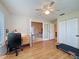 Comfortable office with ceiling fan, wood floors, a desk, and a view of the living room at 1003 Teal Pointe, Tarpon Springs, FL 34689