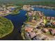 An aerial view of a lakeside community with mature trees and manicured lawns. House location highlighted with arrow at 10528 Bermuda Isle Dr, Tampa, FL 33647