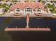 Aerial view of clubhouse on lake with patio, dock, and a brick-tile roof at 10528 Bermuda Isle Dr, Tampa, FL 33647