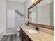 Bathroom vanity features a granite countertop, brown cabinets, a large mirror, and modern fixtures at 10528 Bermuda Isle Dr, Tampa, FL 33647