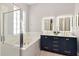 Bathroom with modern vanity, lighted mirrors, soaking tub, and glass-enclosed shower at 10528 Bermuda Isle Dr, Tampa, FL 33647
