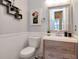 Stylish half bath with wood vanity, modern fixtures and artwork at 10528 Bermuda Isle Dr, Tampa, FL 33647