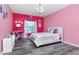 Bright pink bedroom with a white bed, a decorative dream catcher, and a large window at 10528 Bermuda Isle Dr, Tampa, FL 33647