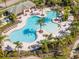 Aerial view of a resort-style community pool area with palm trees and ample seating, offering a luxurious outdoor experience at 10528 Bermuda Isle Dr, Tampa, FL 33647