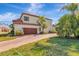 Charming two-story home showcasing a brown garage door, tiled roof, and a well-manicured lawn, capturing curb appeal at 10528 Bermuda Isle Dr, Tampa, FL 33647