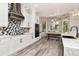 Modern kitchen with white cabinets, a decorative backsplash, and a breakfast nook with large windows at 10528 Bermuda Isle Dr, Tampa, FL 33647