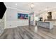 Open living space with gray wood floors connecting the living, dining, and kitchen areas at 10528 Bermuda Isle Dr, Tampa, FL 33647