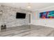 Living room featuring a stone accent wall, modern lighting, and neutral flooring at 10528 Bermuda Isle Dr, Tampa, FL 33647