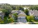 Aerial view of a home with a two-car garage, lush landscaping, and scenic views of a nearby lake at 11209 Pocket Brook Dr, Tampa, FL 33635
