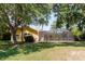 Backyard featuring a yellow house, a screened lanai, well-maintained grass, and a large tree at 11209 Pocket Brook Dr, Tampa, FL 33635