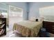 Comfortable bedroom with natural light from large window, features a floral comforter and blue walls at 11209 Pocket Brook Dr, Tampa, FL 33635