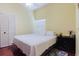 Bright bedroom features wood floor, white comforter, a window, and closet for storage at 11209 Pocket Brook Dr, Tampa, FL 33635