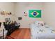 Bedroom featuring wood floors, a bed, a small side table, a desk, and a Brazilian flag at 11209 Pocket Brook Dr, Tampa, FL 33635