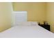 Bright bedroom featuring a window with blinds, wood floors, and a queen size bed with white bedding at 11209 Pocket Brook Dr, Tampa, FL 33635
