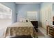 Light and airy bedroom features blue walls, a floral comforter, large window and closet at 11209 Pocket Brook Dr, Tampa, FL 33635