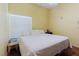 Bright bedroom featuring a window with blinds, wood floors, and a queen size bed with white bedding at 11209 Pocket Brook Dr, Tampa, FL 33635