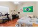 Bright bedroom with wooden floors, ceiling fan, a desk, and a bed with cartoon character themed bedspread at 11209 Pocket Brook Dr, Tampa, FL 33635