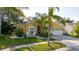 Exterior view of a yellow two-story home with a well-manicured lawn, landscaping, and a three-car garage at 11209 Pocket Brook Dr, Tampa, FL 33635