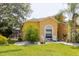 Charming home featuring lush landscaping, white stone accents, and a cozy front seating area with white chairs at 11209 Pocket Brook Dr, Tampa, FL 33635