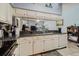 Bright kitchen with white cabinets, granite countertops, and a mirrored backsplash providing view of the adjacent living area at 11209 Pocket Brook Dr, Tampa, FL 33635