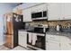 Contemporary kitchen featuring stainless steel appliances, white cabinetry, and black fridge for a modern contrast at 11209 Pocket Brook Dr, Tampa, FL 33635