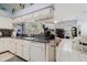 Spacious kitchen featuring white cabinets, granite countertops, and an open view to the adjacent dining and living areas at 11209 Pocket Brook Dr, Tampa, FL 33635