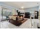 Bright living room with a ceiling fan, fireplace, tile floors, and sliding glass doors leading to an outdoor patio at 11209 Pocket Brook Dr, Tampa, FL 33635