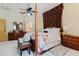 Spacious main bedroom featuring a four-poster bed, ceiling fan, and tiled flooring at 11209 Pocket Brook Dr, Tampa, FL 33635