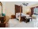Primary bedroom featuring a four-poster bed, tile floors, and private backyard views at 11209 Pocket Brook Dr, Tampa, FL 33635