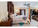 Well-lit main bedroom with four-poster bed, ceiling fan, and dresser at 11209 Pocket Brook Dr, Tampa, FL 33635