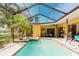 Relax in this screened in pool and spa, complemented by the outdoor kitchen at 11209 Pocket Brook Dr, Tampa, FL 33635