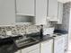 Kitchen showcases gray cabinets, mosaic backsplash, and modern appliances for seamless cooking at 11405 3Rd N St # 2, St Petersburg, FL 33716