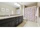 Bathroom featuring a granite countertop vanity, framed mirror, and shower with floral curtain at 11852 Lake Lucaya Dr, Riverview, FL 33579