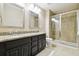 Well-lit bathroom featuring a double vanity with granite countertops and a glass-enclosed shower at 11852 Lake Lucaya Dr, Riverview, FL 33579