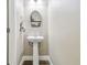 Powder room featuring a pedestal sink, framed oval mirror with shelving, and tile floors at 11852 Lake Lucaya Dr, Riverview, FL 33579