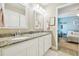 Elegant bathroom with double sinks, framed mirrors, and granite countertops, leading to a bedroom at 11852 Lake Lucaya Dr, Riverview, FL 33579