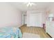 Cozy pink bedroom featuring hardwood floors, double closets, and a playful rug at 11852 Lake Lucaya Dr, Riverview, FL 33579