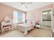 Well-lit bedroom with light pink walls, a vanity, and a cozy seating area near the window at 11852 Lake Lucaya Dr, Riverview, FL 33579