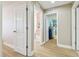 Hallway featuring light hardwood floors, multiple doors, and bright, neutral-toned walls at 11852 Lake Lucaya Dr, Riverview, FL 33579