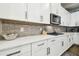 Modern kitchen featuring white cabinetry, stainless steel appliances, and a tile backsplash for a sleek and stylish look at 11852 Lake Lucaya Dr, Riverview, FL 33579