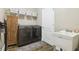 Laundry room features modern washer and dryer, utility sink, storage cabinets, and tile floors at 11852 Lake Lucaya Dr, Riverview, FL 33579