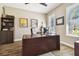Well-lit office with wood-look tile flooring, a large desk, and built-in shelving, perfect for a productive workspace at 11852 Lake Lucaya Dr, Riverview, FL 33579
